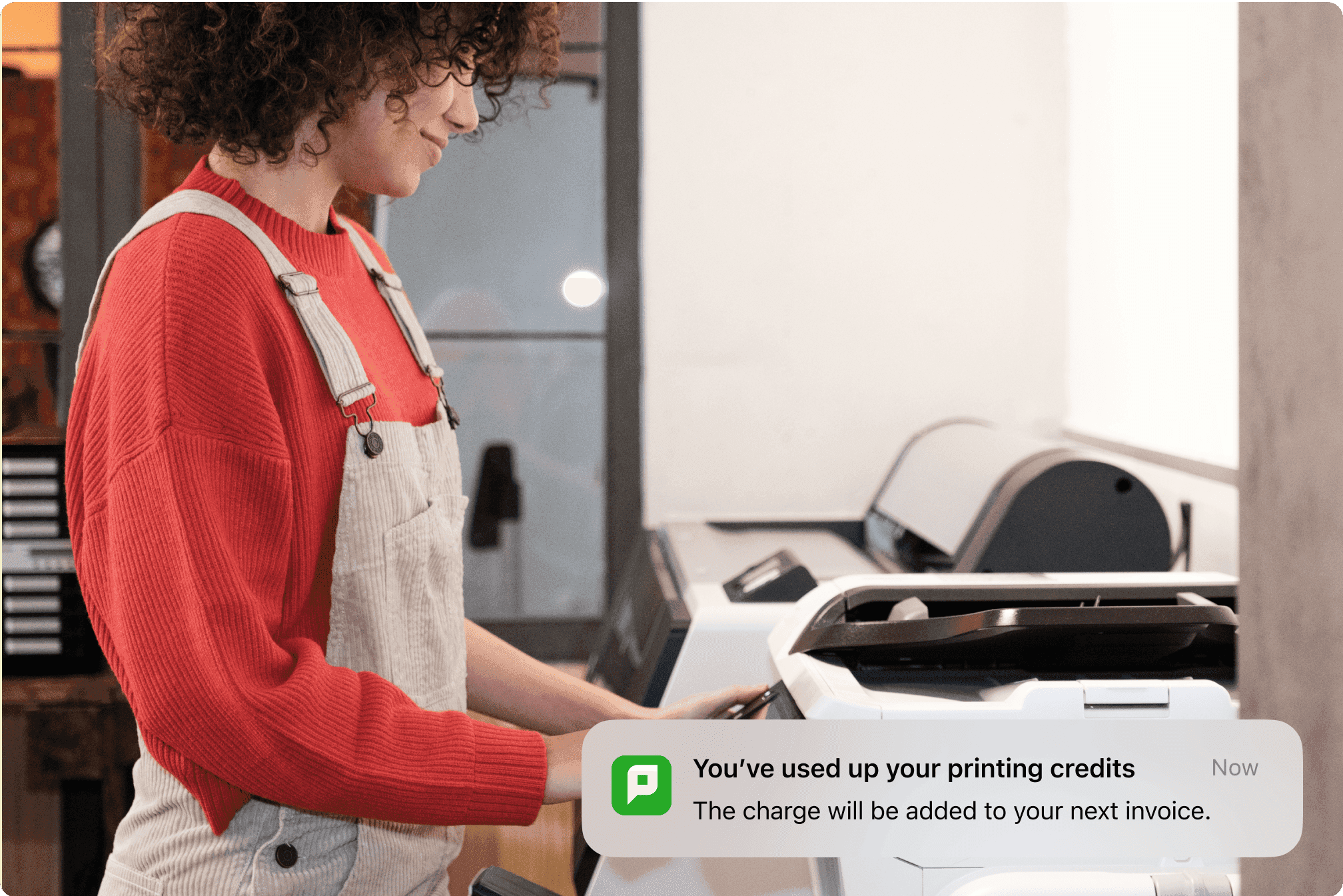 A person using a printer with a notification indicating that printing credits have been used up.